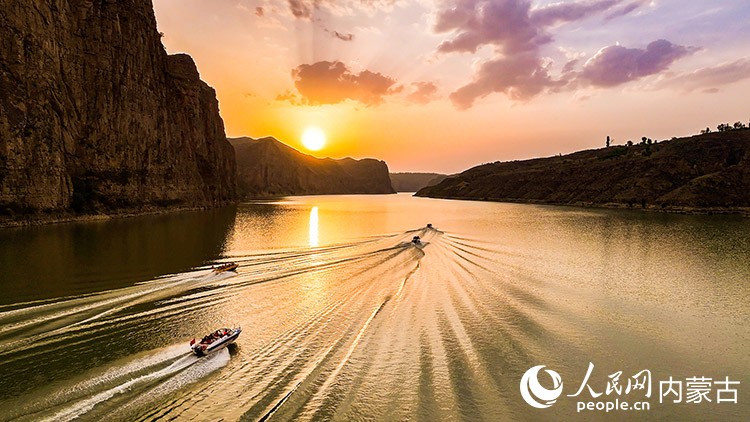 夕陽下游船在老牛灣黃河大峽谷駛過。王劭凱攝