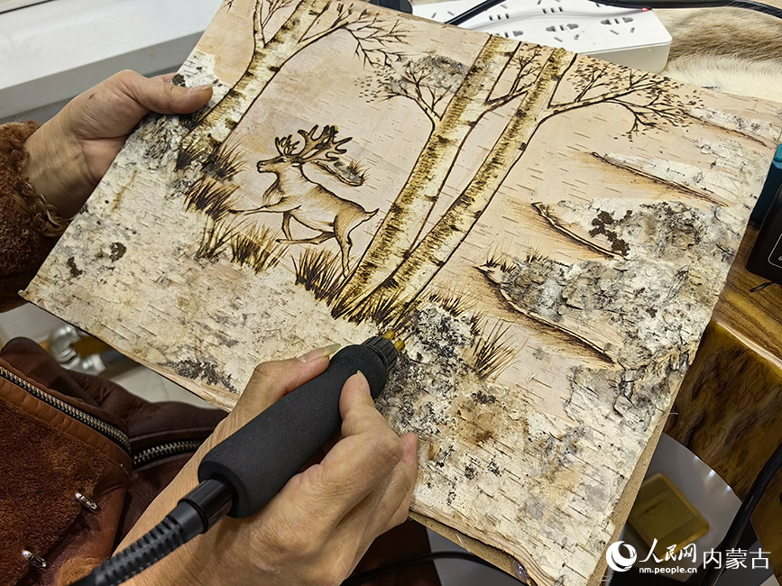 敖魯古雅太陽城文創市集內手工藝傳承者在制作樺樹皮畫。人民網記者 富麗娟攝