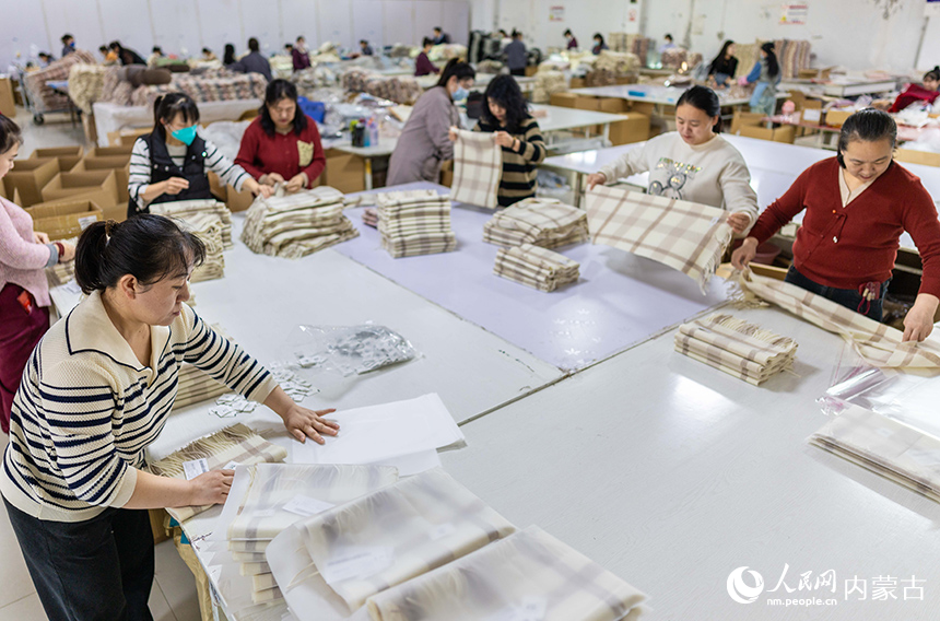 內蒙古呼和浩特市玉泉區裕隆產業園精卓羊絨制品有限公司的生產車間內，工人在生產線上趕制羊絨制品訂單。丁根厚攝