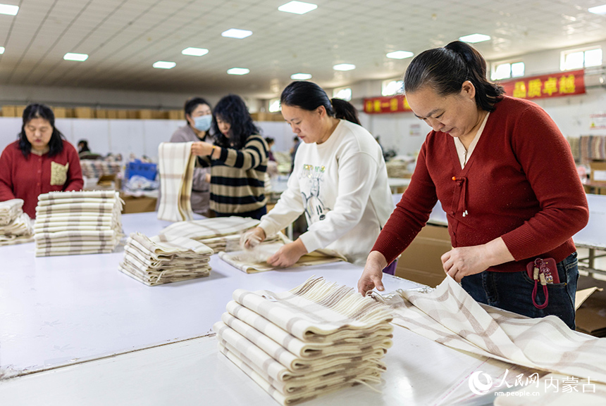 內蒙古呼和浩特市玉泉區裕隆產業園精卓羊絨制品有限公司的生產車間內，工人在生產線上趕制羊絨制品訂單。丁根厚攝