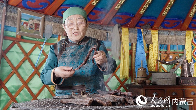 非物質文化遺產代表性傳承人白秀枝正在制作炭烤牛肉干。人民網記者 張力洋攝