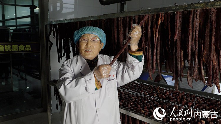 白秀枝在非遺工坊的晾曬車間展示風干中的牛肉干。李旭明攝
