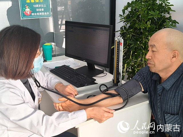 內(nèi)蒙古呼和浩特賽罕區(qū)金豐社區(qū)衛(wèi)生服務(wù)站為居民測(cè)量血壓。實(shí)習(xí)生 漸溫婷攝