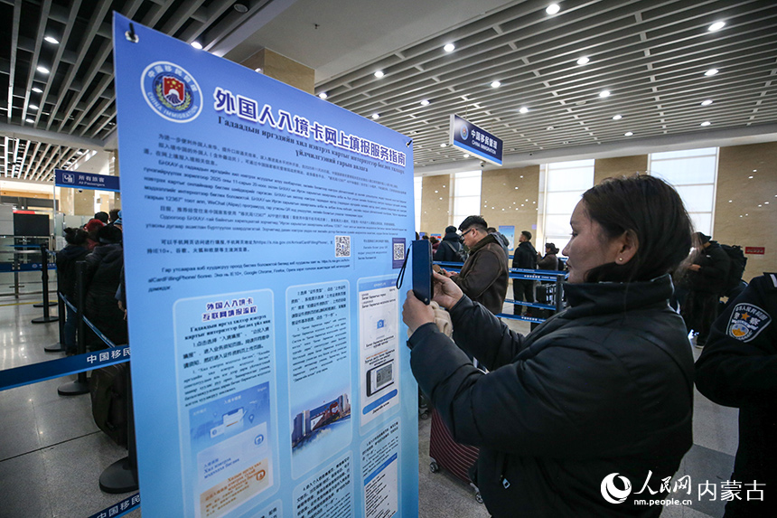 一名蒙古國旅客使用手機掃碼進行外國人入境卡網上填報。郭鵬杰攝