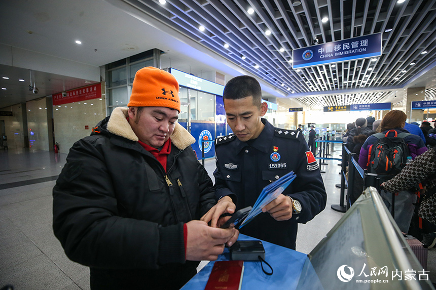 二連出入境邊防檢查站移民管理警察協助蒙古國旅客網上填報外國人入境卡。郭鵬杰攝