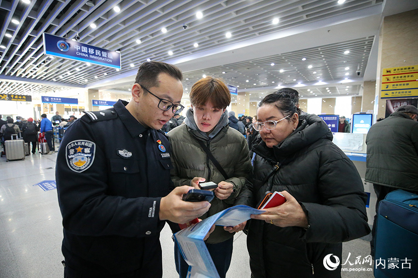 二連出入境邊防檢查站移民管理警察協(xié)助蒙古國旅客網(wǎng)上填報外國人入境卡。郭鵬杰攝