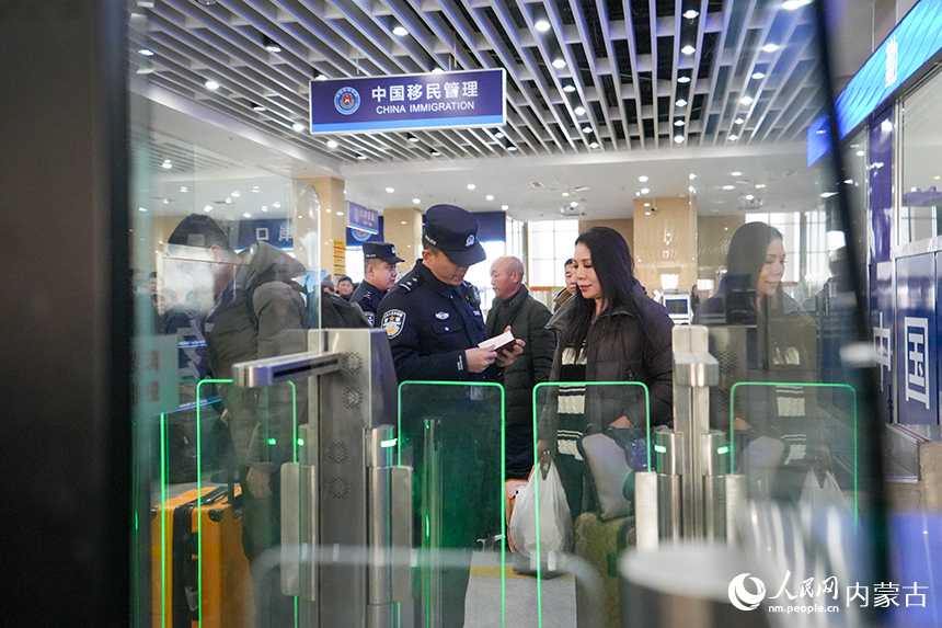 內(nèi)蒙古出入境邊防檢查總站二連出入境邊防檢查站移民管理警察為旅客提供高效通關(guān)服務(wù)。楊金燁攝
