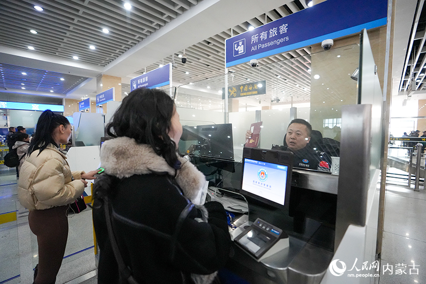 內(nèi)蒙古出入境邊防檢查總站二連出入境邊防檢查站移民管理警察正在為旅客辦理通關(guān)手續(xù)。楊金燁攝
