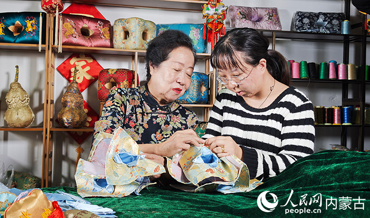 六合枕制作技藝傳承人溫永華教授徒弟如何縫制六合枕。人民網記者 張雪冬攝