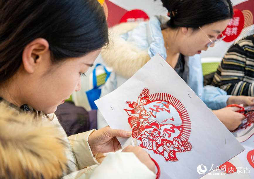 12月4日，呼和浩特市玉泉區清泉街社區的工作人員在“國家憲法日”主題活動上制作剪紙作品。丁根厚攝