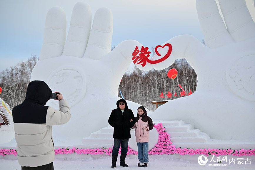游客與雪雕合影。人民網(wǎng)記者 寇雅楠攝
