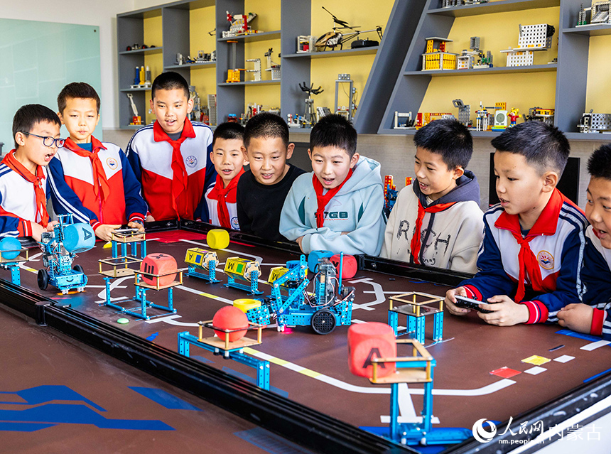 呼和浩特市玉泉區石東路小學機器人社團的學生在操控編程機器人。丁根厚攝