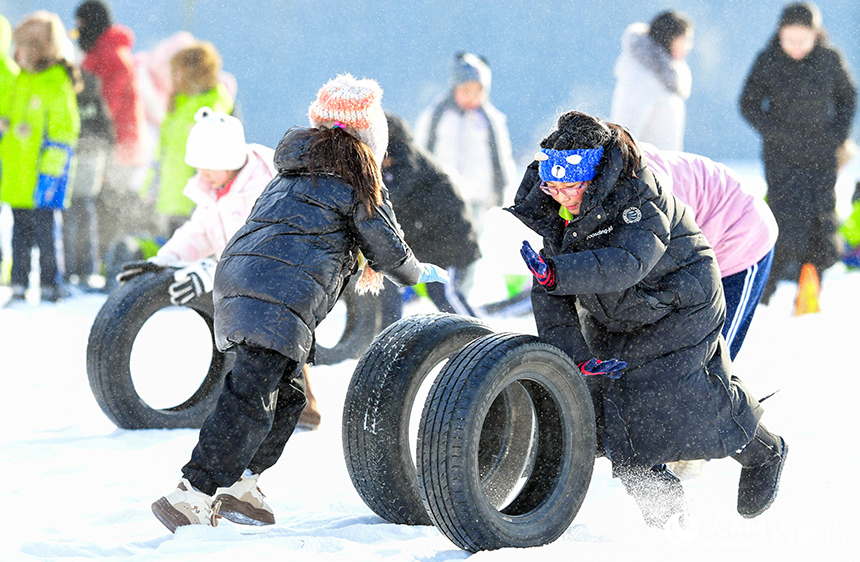 牙克石市第二小學學生在大課間參加雪地滾輪胎活動。王正攝