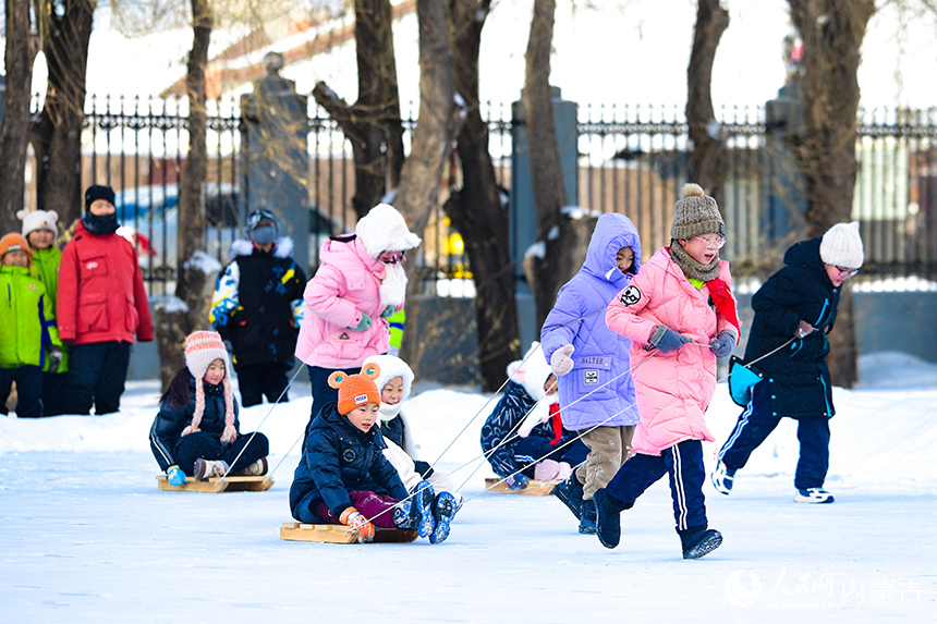牙克石市第二小學(xué)學(xué)生在大課間參加冰上爬犁活動(dòng)。王正攝
