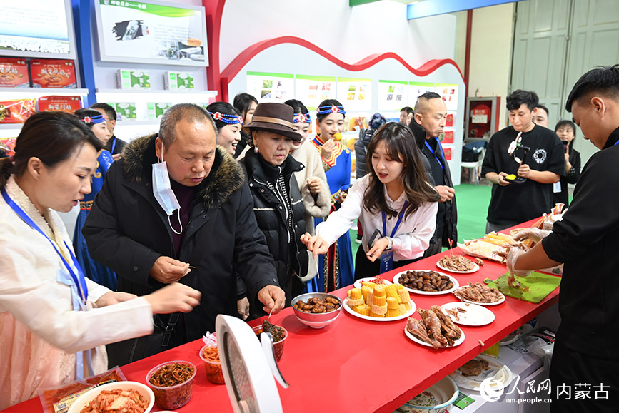 阿榮旗展區(qū)內(nèi)，游客正在試吃特色食品。人民網(wǎng)記者 劉藝琳攝