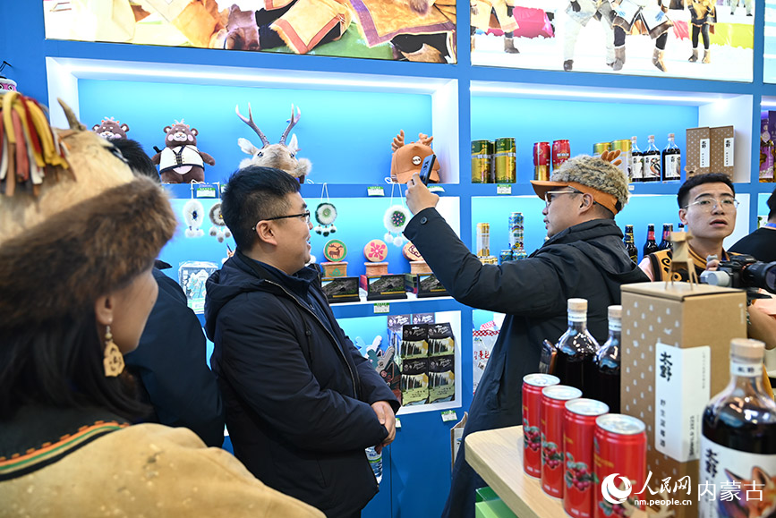 鄂倫春展區內，游客正在試戴帽子。人民網記者 劉藝琳攝