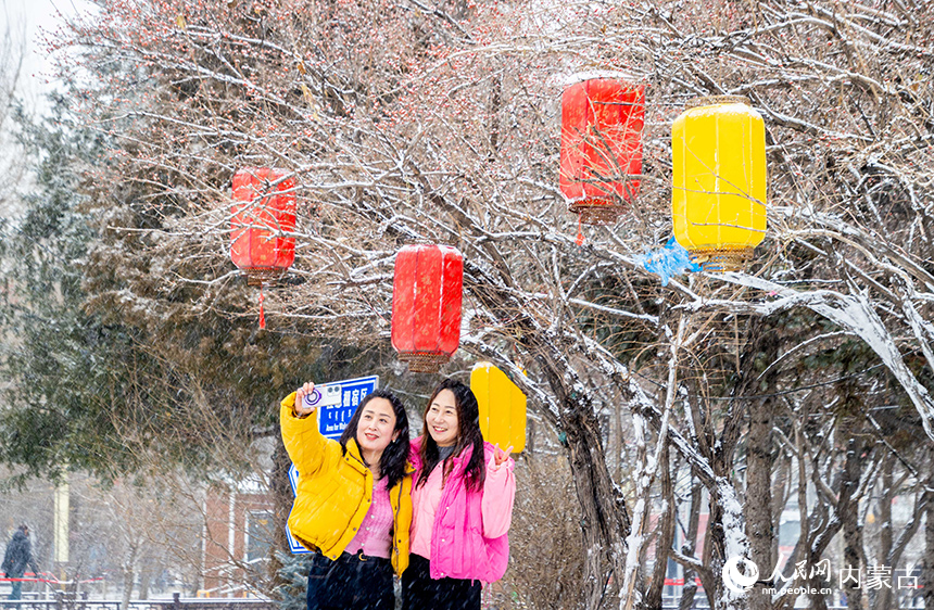 游人在呼和浩特市玉泉區塞上老街旅游休閑街區賞雪拍照。丁根厚攝