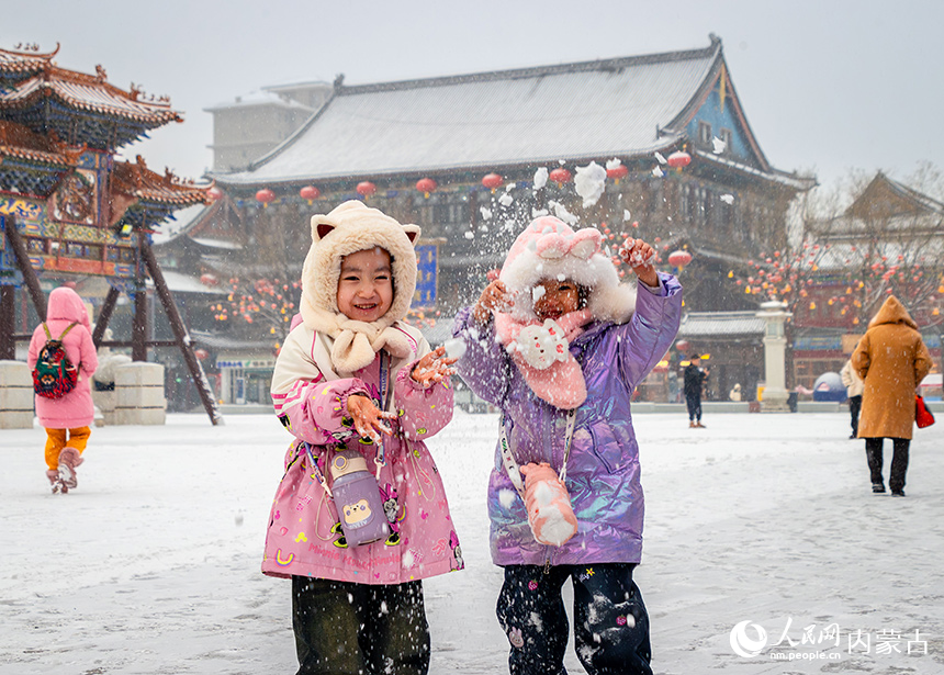 小朋友呼和浩特市玉泉區(qū)塞上老街旅游休閑街區(qū)戲雪游玩。丁根厚攝