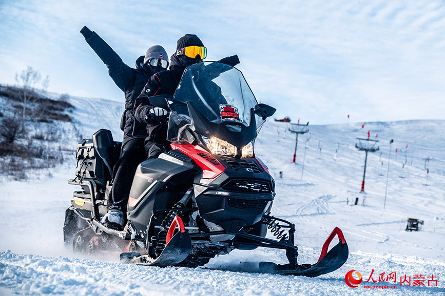 12月22日，游客在牙克石鳳凰山景區駕駛雪地摩托，體驗在林海雪原間穿梭的速度與激情。呂昊俊攝
