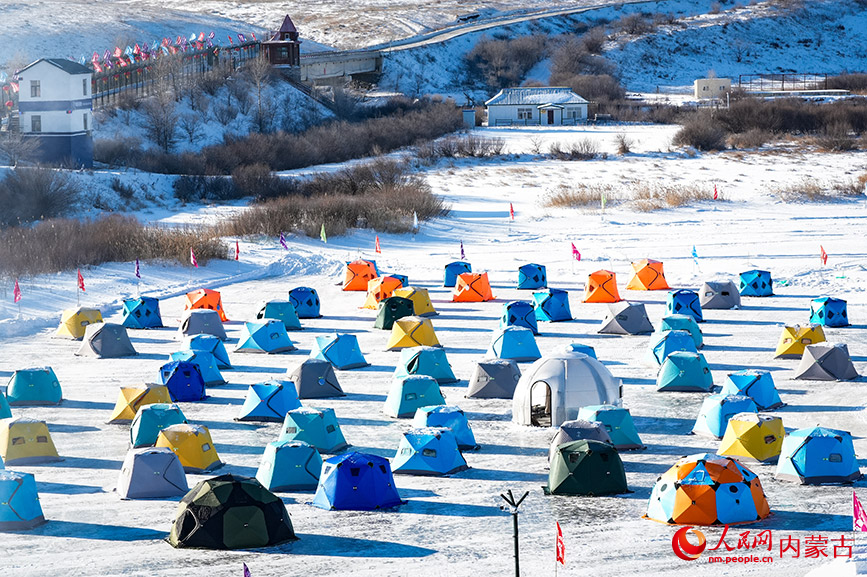 鳥瞰額爾古納第三屆中俄界河冰釣活動現(xiàn)場，暖帳如花綻放在冰河之上，勾勒出一幅跨境冰雪交融的生動畫卷。實習生 牛佳攝